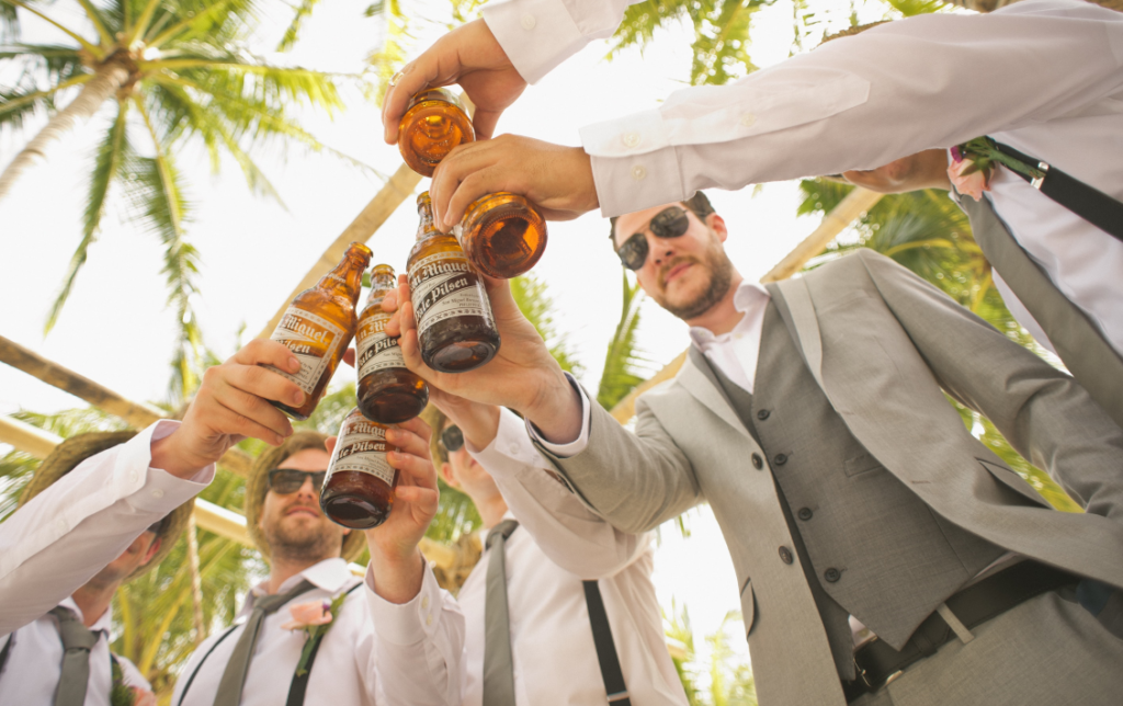 A close-up shot of the hands of a bride and groom holding glasses of wine