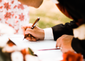 Wedding register on a pedestal beside a small bouquet of flowers